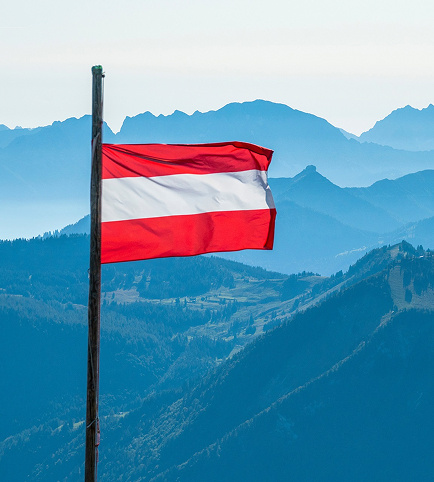 Flag against a mountain panorama, symbolic image for Dr. Hartmann Chemietechnik Austria